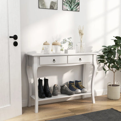 White console table with shoes and decor items in a room with a plant and door.