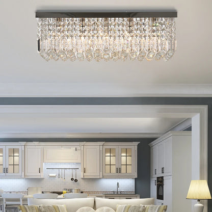 Modern kitchen with a crystal chandelier and white cabinets.