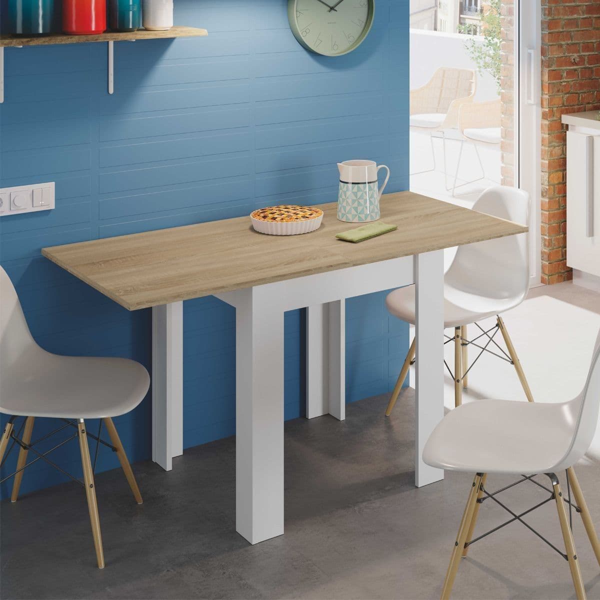 Dining area with a wooden table and white chairs against a blue wall.