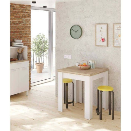 Small dining area with a wooden table and yellow stools in a modern kitchen.