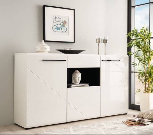 Modern white sideboard in a living room setting with decor items and a plant.