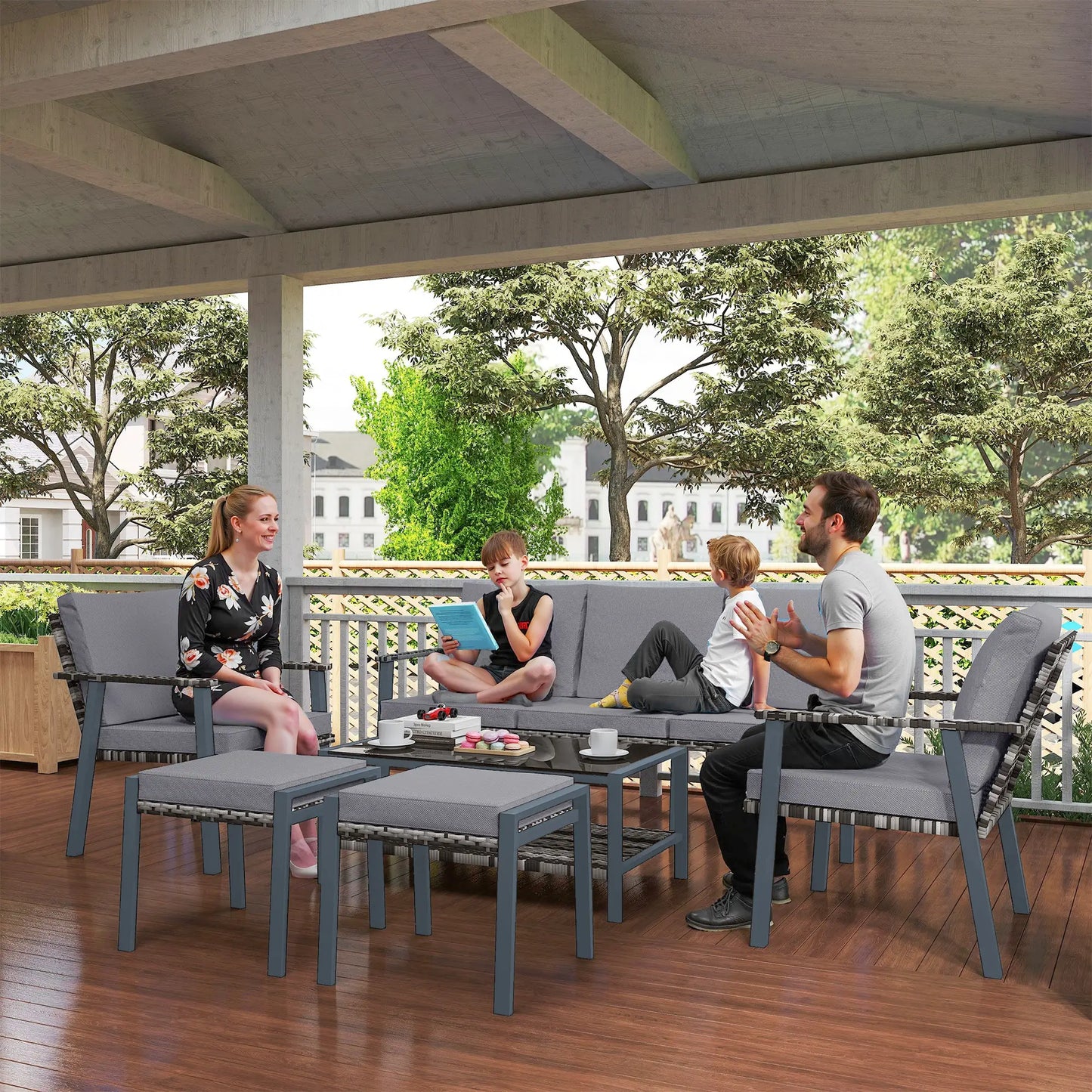 Family sitting on outdoor furniture set on a wooden deck with trees in the background